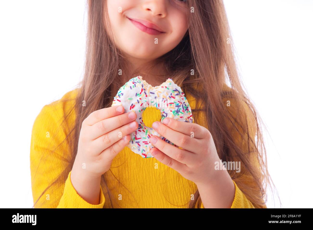 Sweet little girl eating white donut Stock Photo