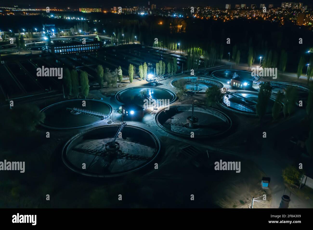 Modern wastewater treatment plant, aerial view at night. Tanks for aeration and purification of sewage. Stock Photo