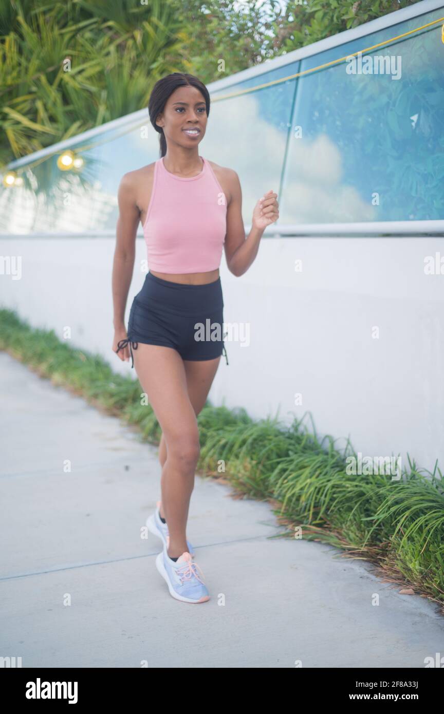 Portrait of a Young African American Woman Jogging and Walking outside along the water Stock Photo
