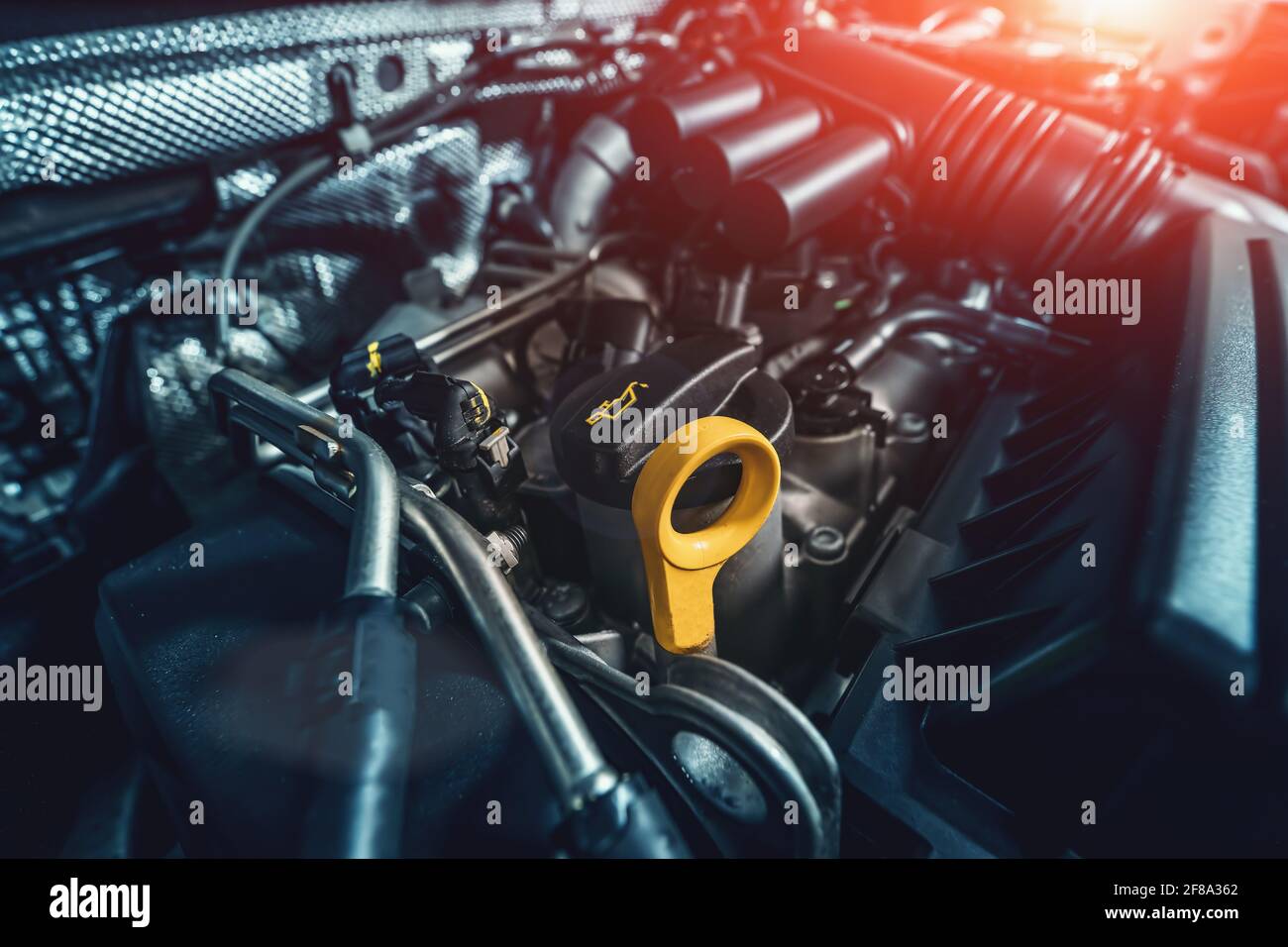 Engine compartment under car hood with emphasis on oil dipstick