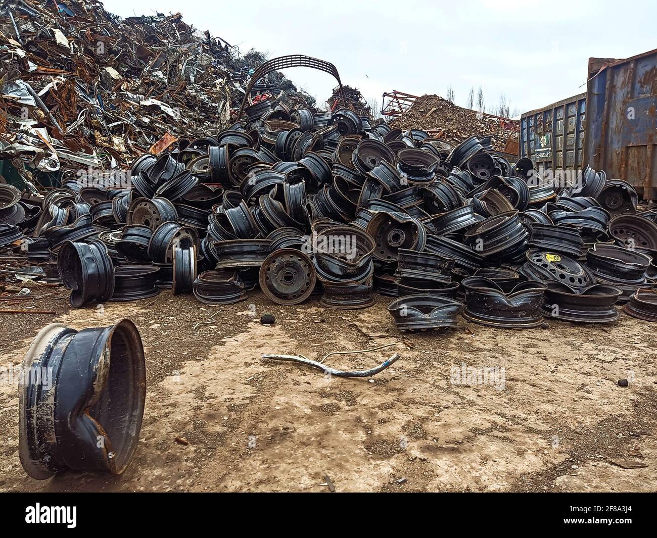 A pile of broken car rims in a junkyard. Worn metal car rims ready for ...