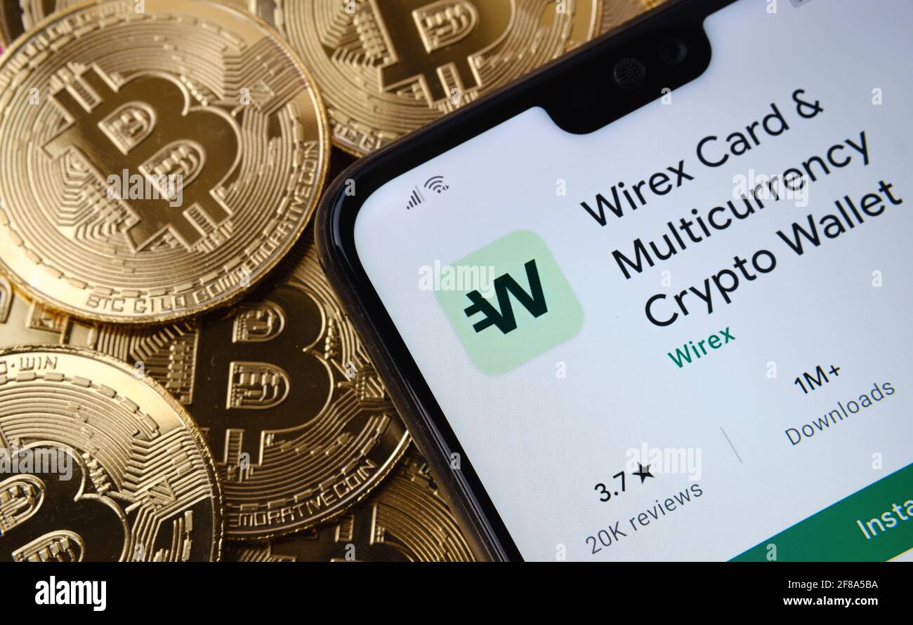 Wirex Card app seen on the smartphone screen placed on top bitcoin coins pile. Concept. Stafford, United Kingdom, April 12, 2021. Stock Photo