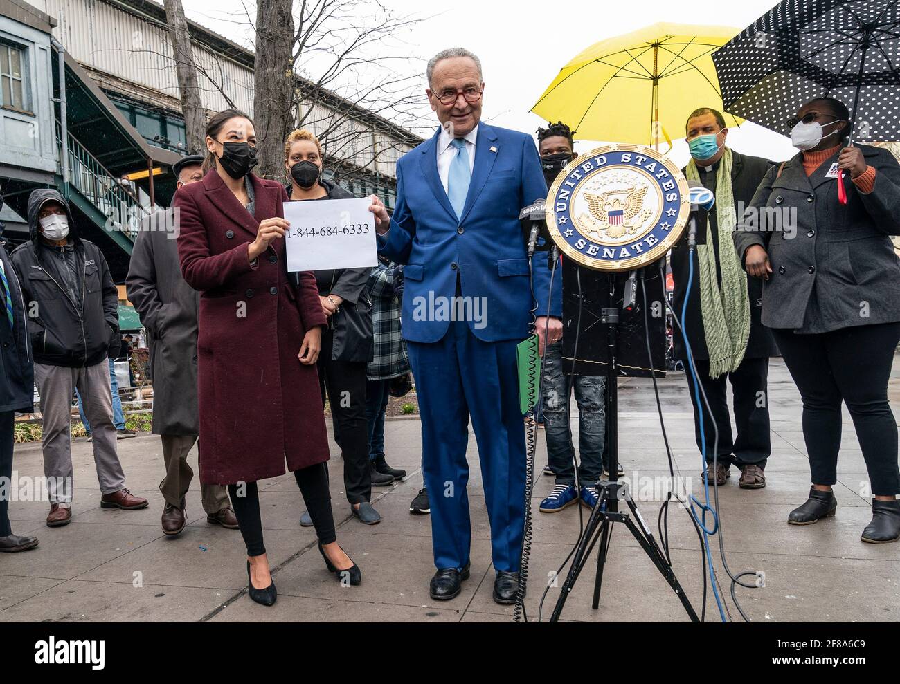 U. S. Representative Alexandria Ocasio-Cortez and Senate Majority Leader Charles Schumer hold paper with printed FEMA hotline number for help with funeral expenses for COVID-19 related deaths at joint presser on Corona Plaza. U.S. Senator Charles Schumer and Congresswoman Alexandria Ocasio-Cortez announced the Federal Emergency Management Administration hotline number to help pay for the funeral and burial of COVID-hit families that cannot afford it. During announcement Schumer and Ocasio-Cortez were joined by local activists and residents. (Photo by Lev Radin/Pacific Press) Stock Photo