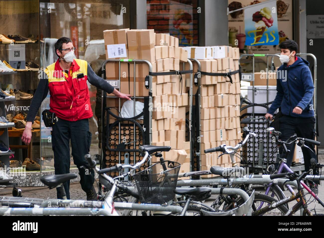 Berlin, Germany. 12th Apr, 2021. A courier wearing a face mask hauls packages in Berlin, capital of Germany, on April 12, 2021. More than three million COVID-19 infections have been registered in Germany on Monday since the outbreak of the pandemic, according to the Robert Koch Institute (RKI). Credit: Stefan Zeitz/Xinhua/Alamy Live News Stock Photo