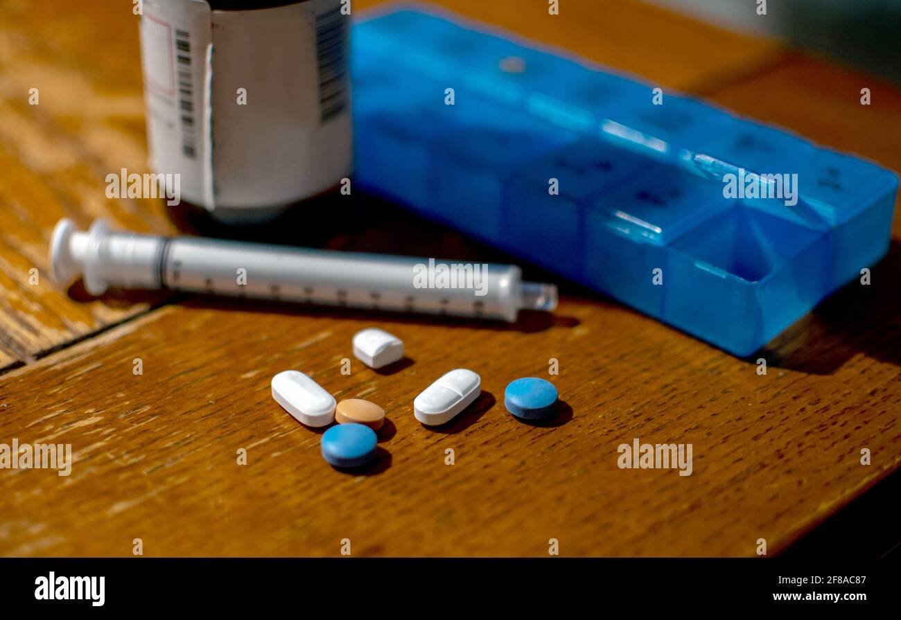 Medicine cabinet with pill bottles and syringe Stock Photo - Alamy