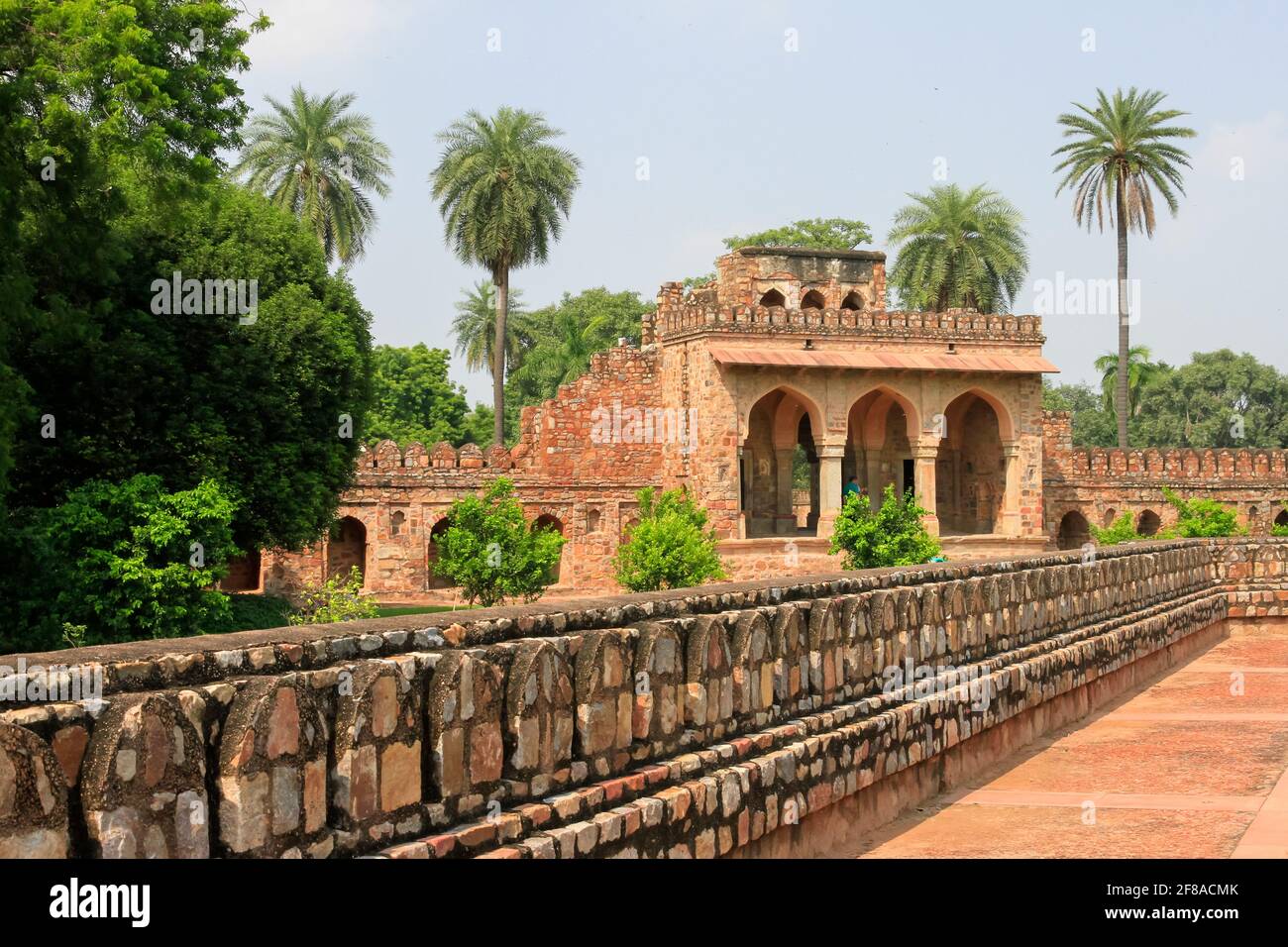 Red building with stone wall at Itmad-Ud-Daulah or baby Taj Mahal in Agra India with palm trees Stock Photo