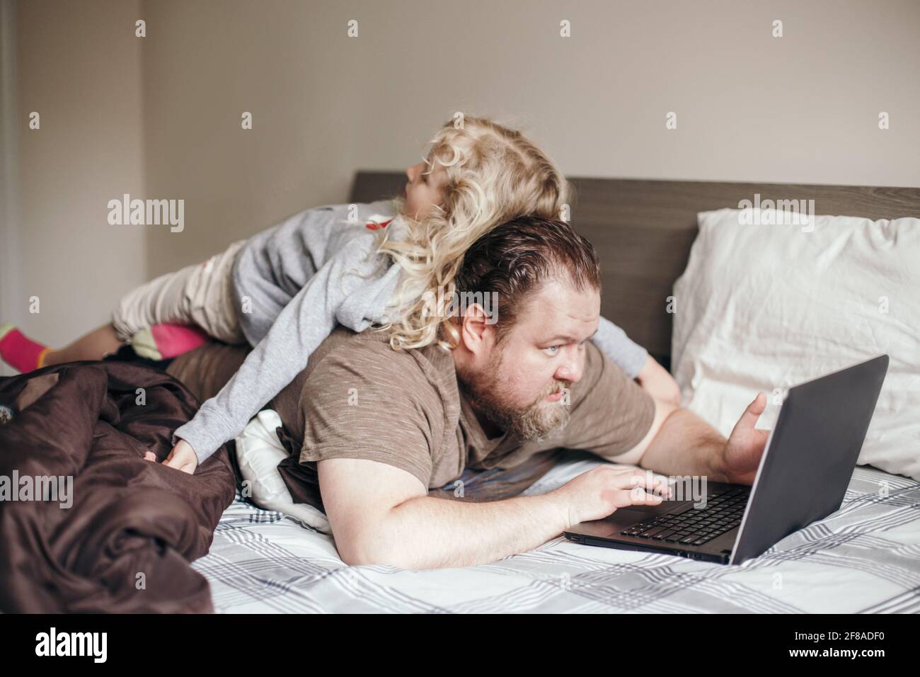 Work from home with kids children. Father working on laptop in ...