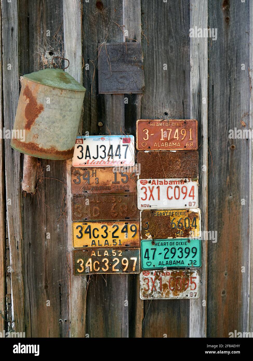 Old, vintage antique Alabama license plates nailed to the side of an old cabin in rural Alabama, USA. Stock Photo