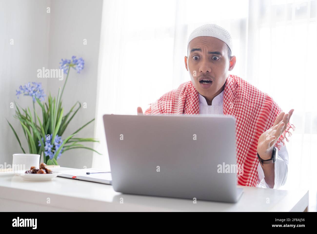 confuse asian muslim business man using laptop Stock Photo