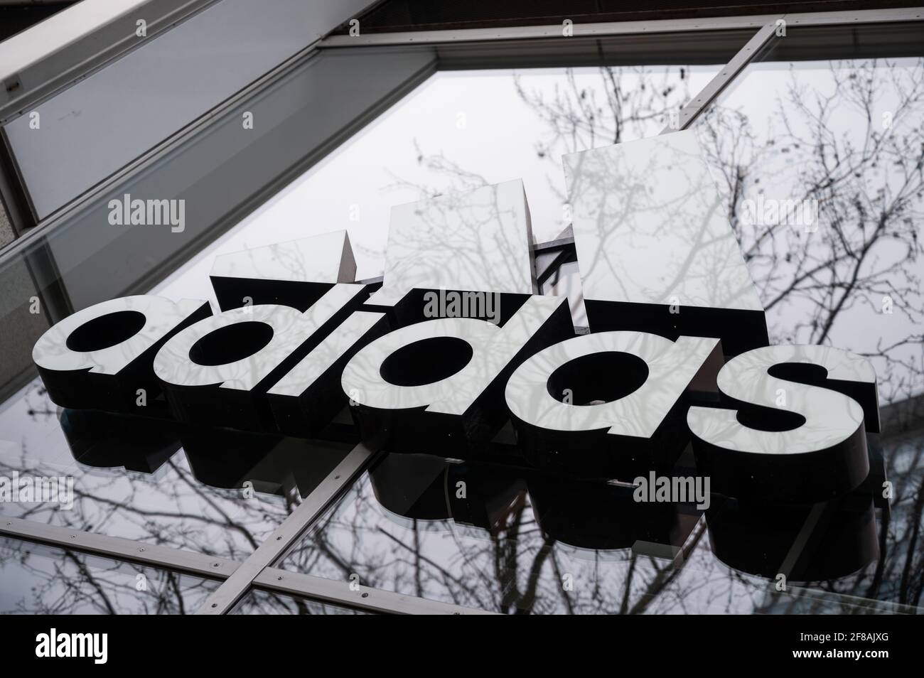 Berlin, Germany. 12th Apr, 2021. The company's logo hangs on the façade of  the Adidas store on Tauentzienstrasse. Big brand manufacturers like Adidas,  Miele and Co. are increasingly bypassing retailers and selling