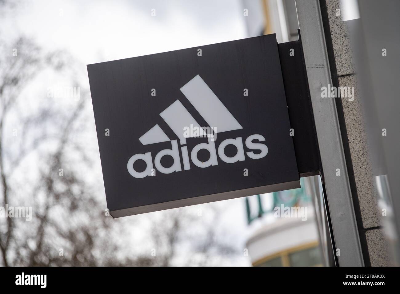 Berlin, Germany. 12th Apr, 2021. The company's logo hangs on the façade of  the Adidas store on Tauentzienstrasse. Big brand manufacturers like Adidas,  Miele and Co. are increasingly bypassing retailers and selling