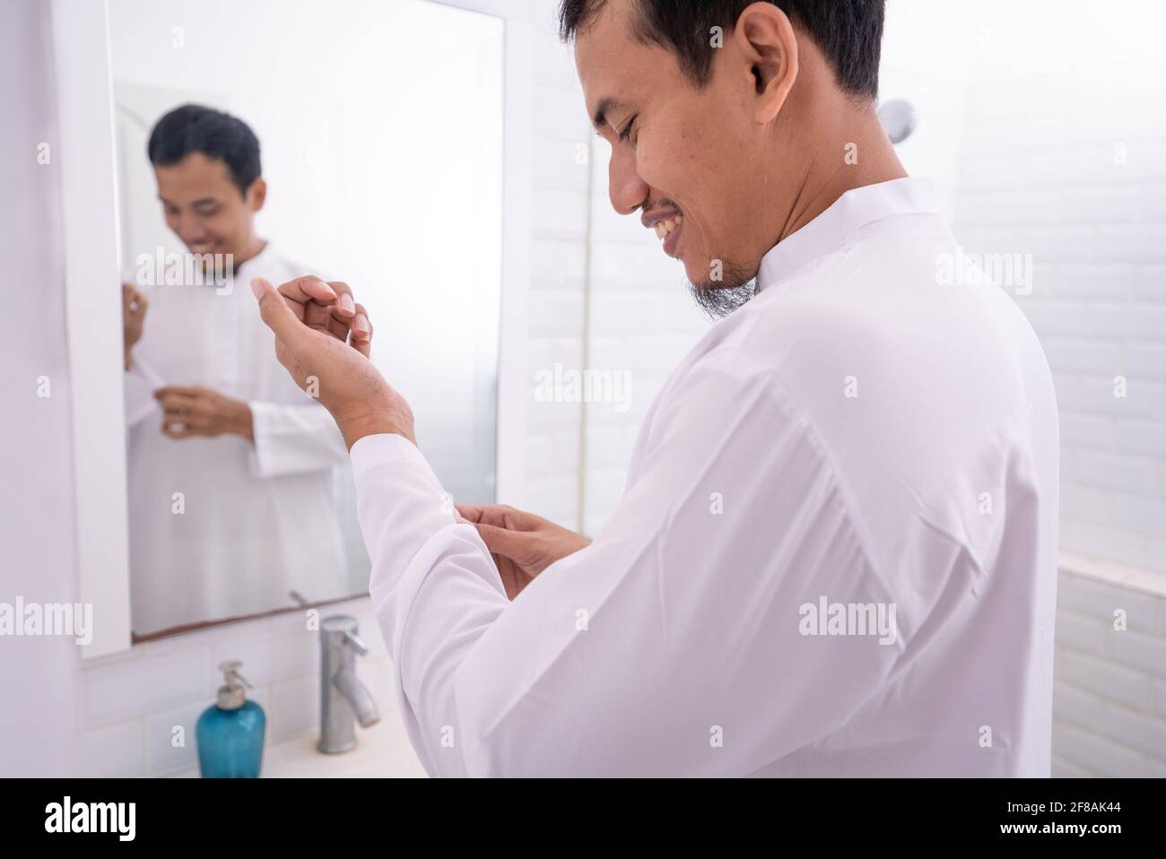 muslim man looking at mirror and get dressed before going to the mosque