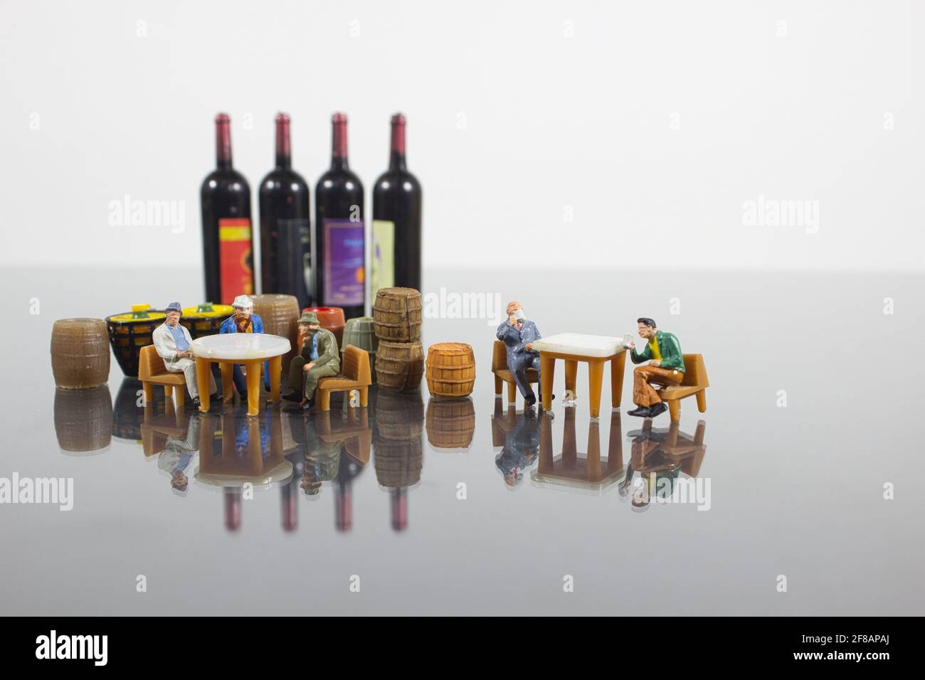 A minifigures of sitting around tables, surrounded by wine barrels and bottles Stock Photo