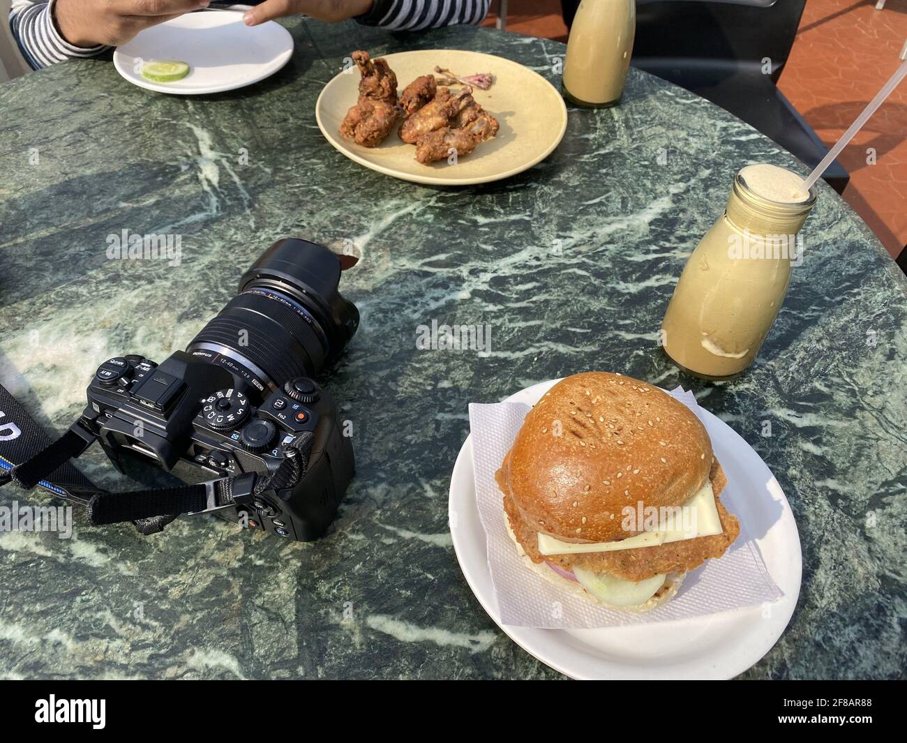 DARJEELING, INDIA - Apr 12, 2021: Burger and chicken pakora with camera at table top Stock Photo