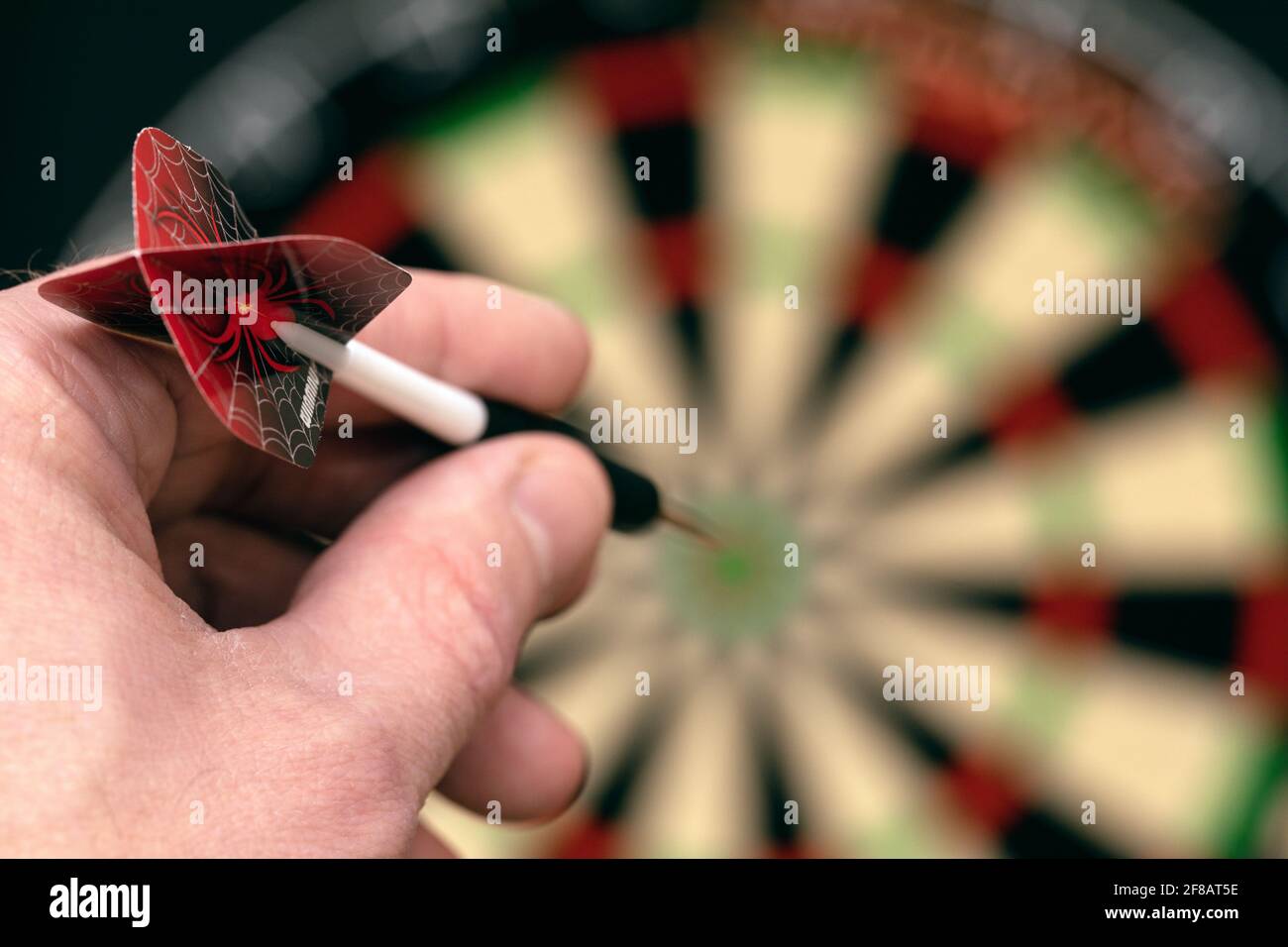 Man hand is holding dart and aiming at target. Achieving goal. game of