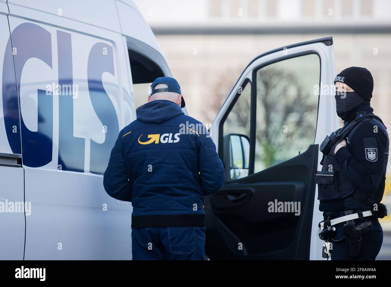 Bornheim, Germany. 13th Apr, 2021. A customs officer checks a GLS delivery  vehicle. Customs and police inspected parcel delivery drivers. They checked  whether drivers were employed via subcontractor chains below the legal