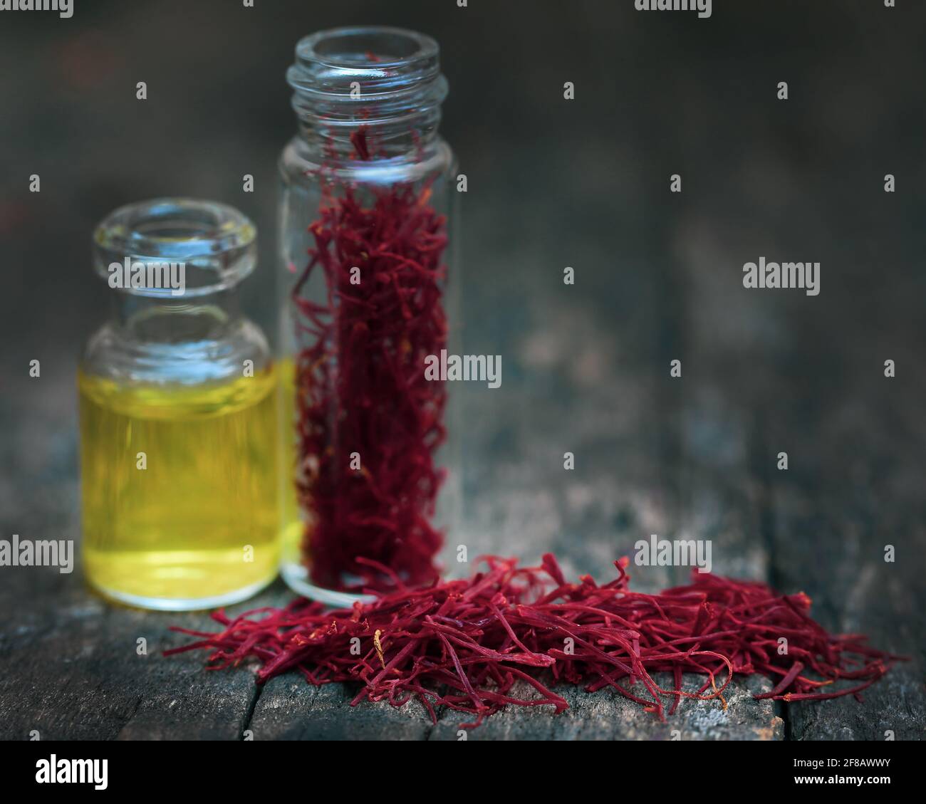 Closeup of Saffron with extract in a bottle on natural surface Stock Photo