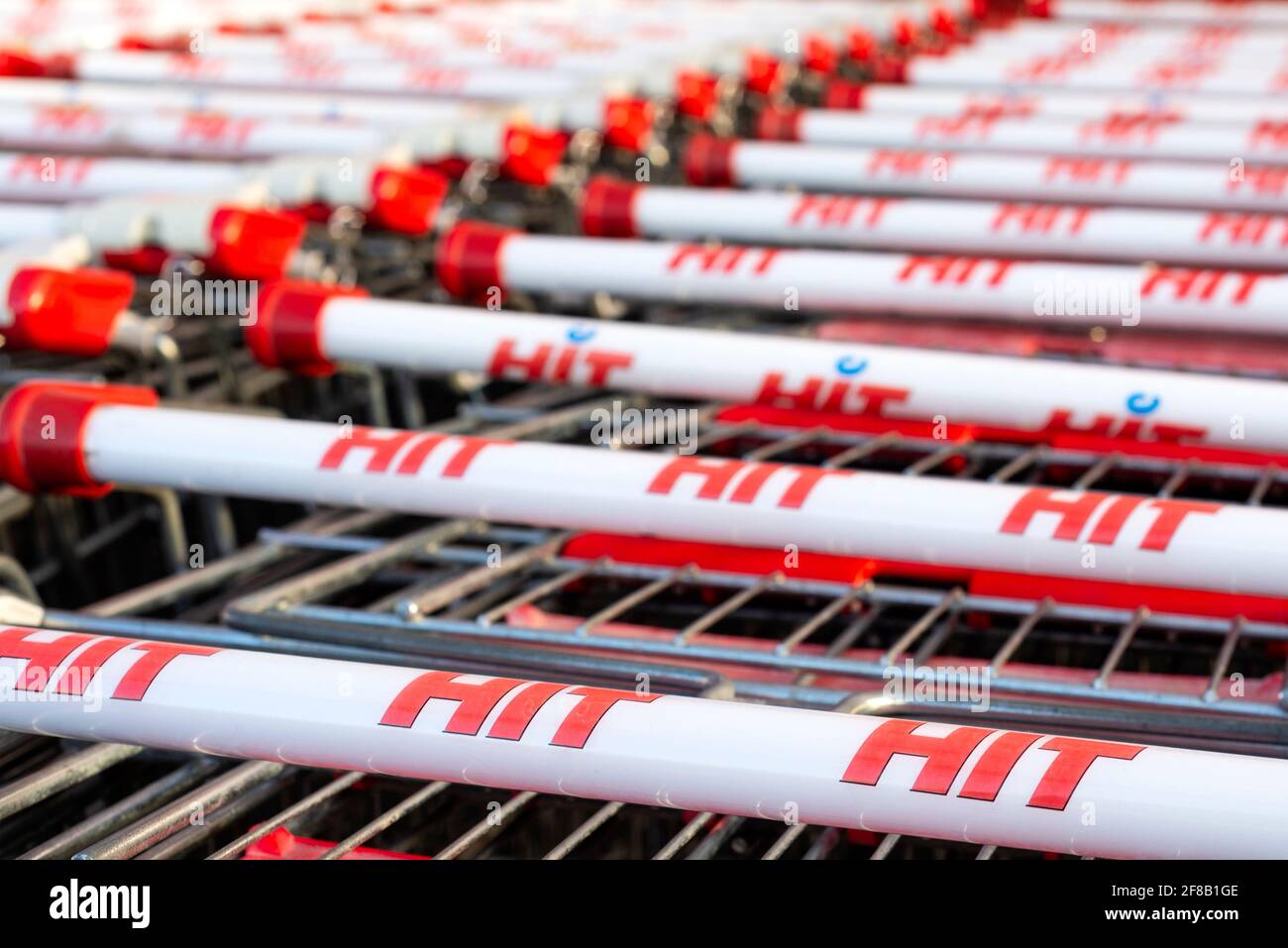 Hit supermarket red and white branded shopping trolleys or shopping carts stacked. Stock Photo