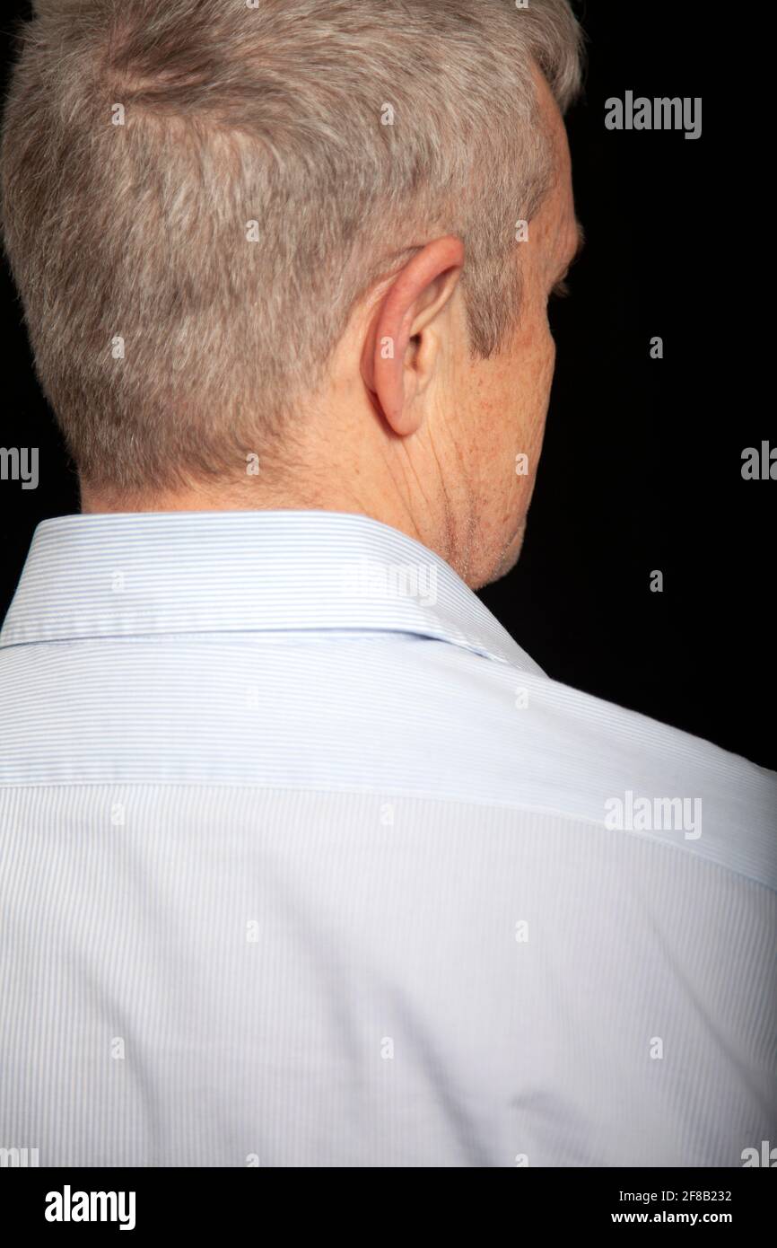 Back of Senior Man Against Black Background Stock Photo