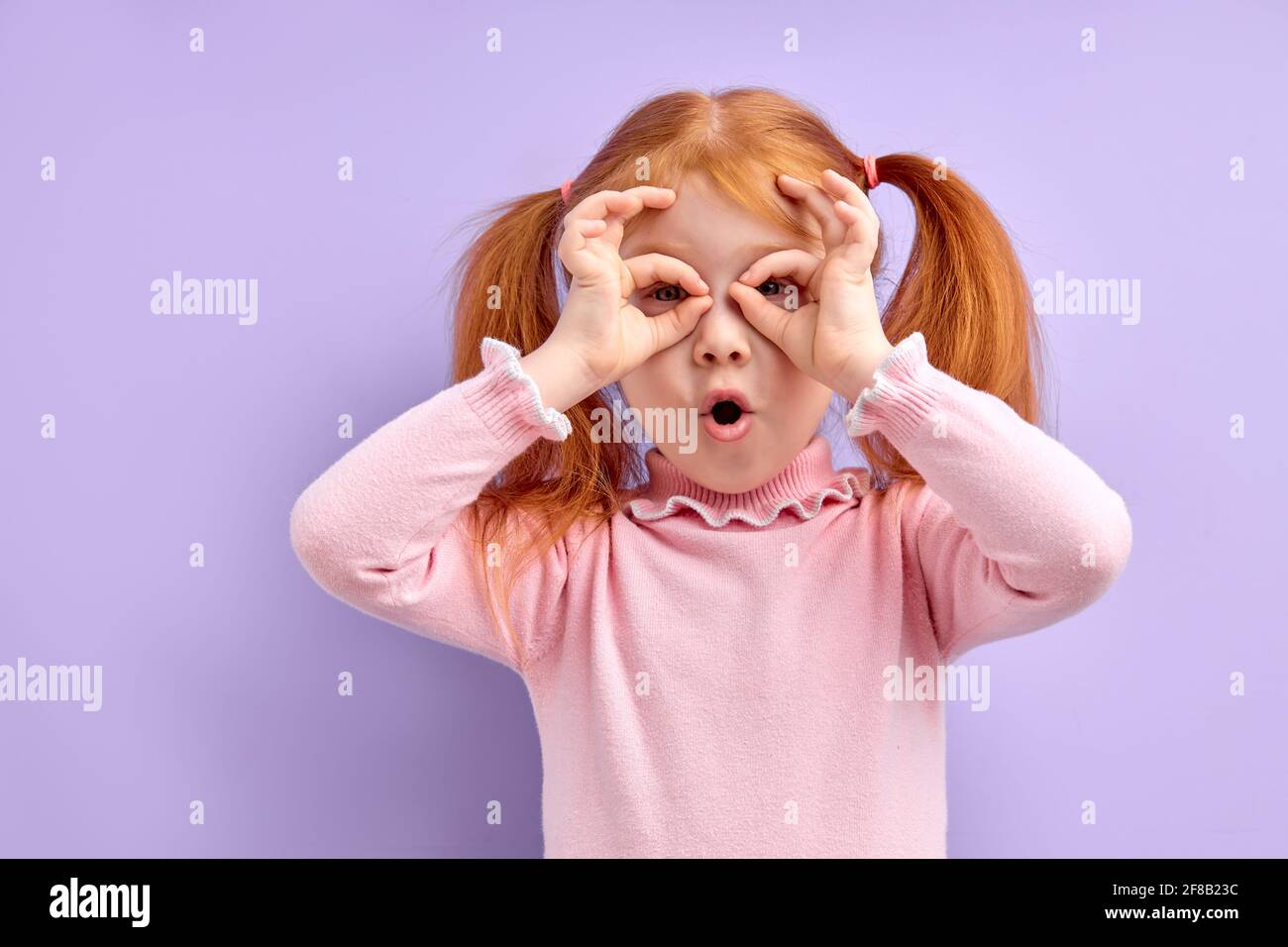 Portrait of surprised cute little girl child standing isolated over ...