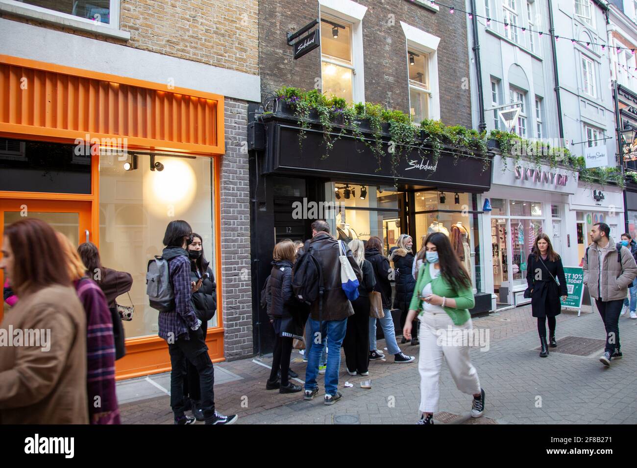 First Day after Lockdown, 12 April 2021, Shoppers Queue to Enter Boutique on Carnaby Street, London, W1 - London UK Stock Photo