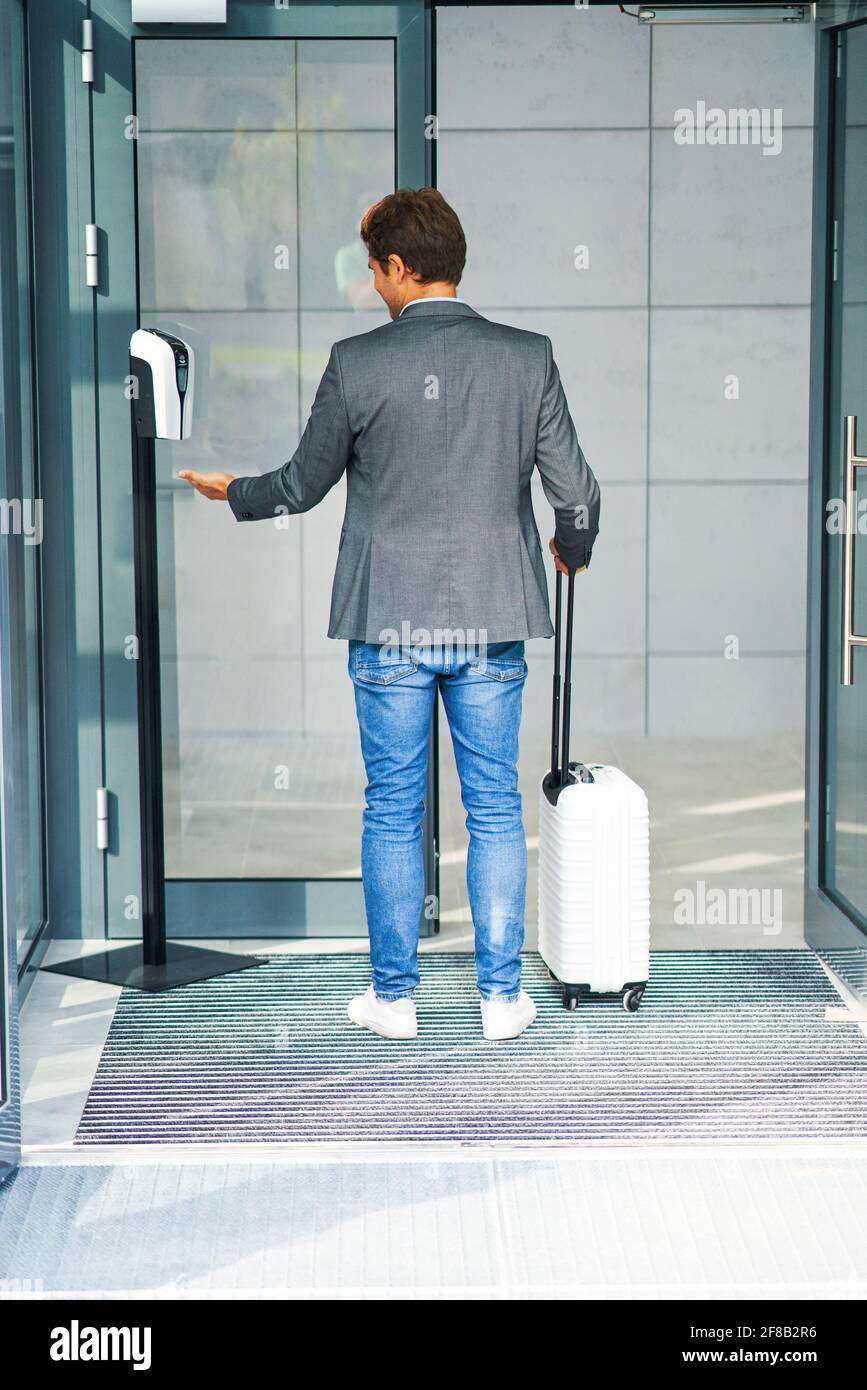 Businessman Entering Building Using Hand Sanitizer Due To Covid 19 Stock Photo Alamy
