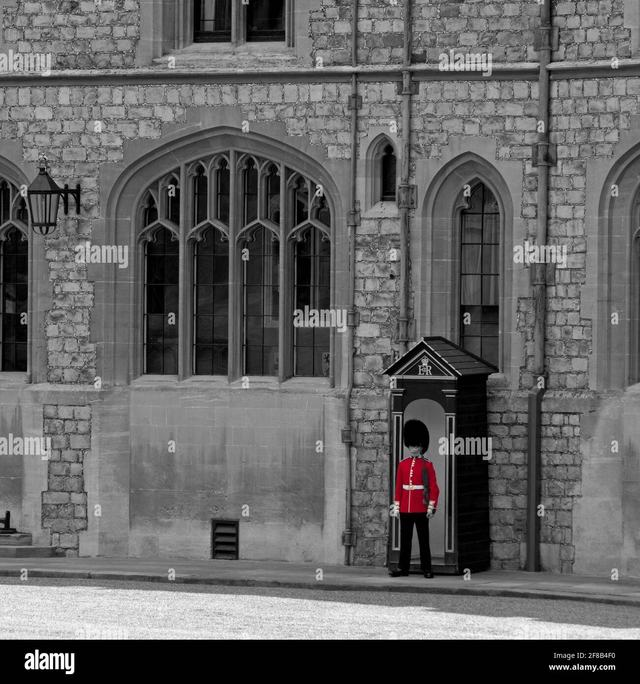 The royal residence of Windsor Castle, Berkshire, UK; the Upper Ward in black and white with red colouring of sentry's tunic. Stock Photo