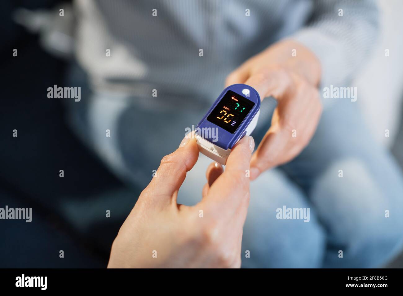 Pulse oximeter, finger digital device to measure oxygen saturation in  blood. Close up view of doctor hand measuring oxygenation level of female  unrecognizable patient for exclusion of pneumonia Stock Photo - Alamy