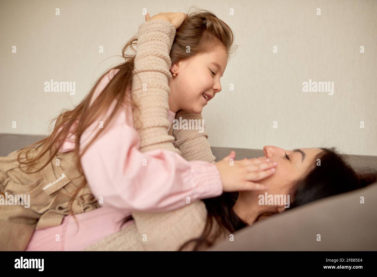 Close Up Of Cute Little Preschool Girl Play With Young Mother Small Daughter Hug Embrace Happy 