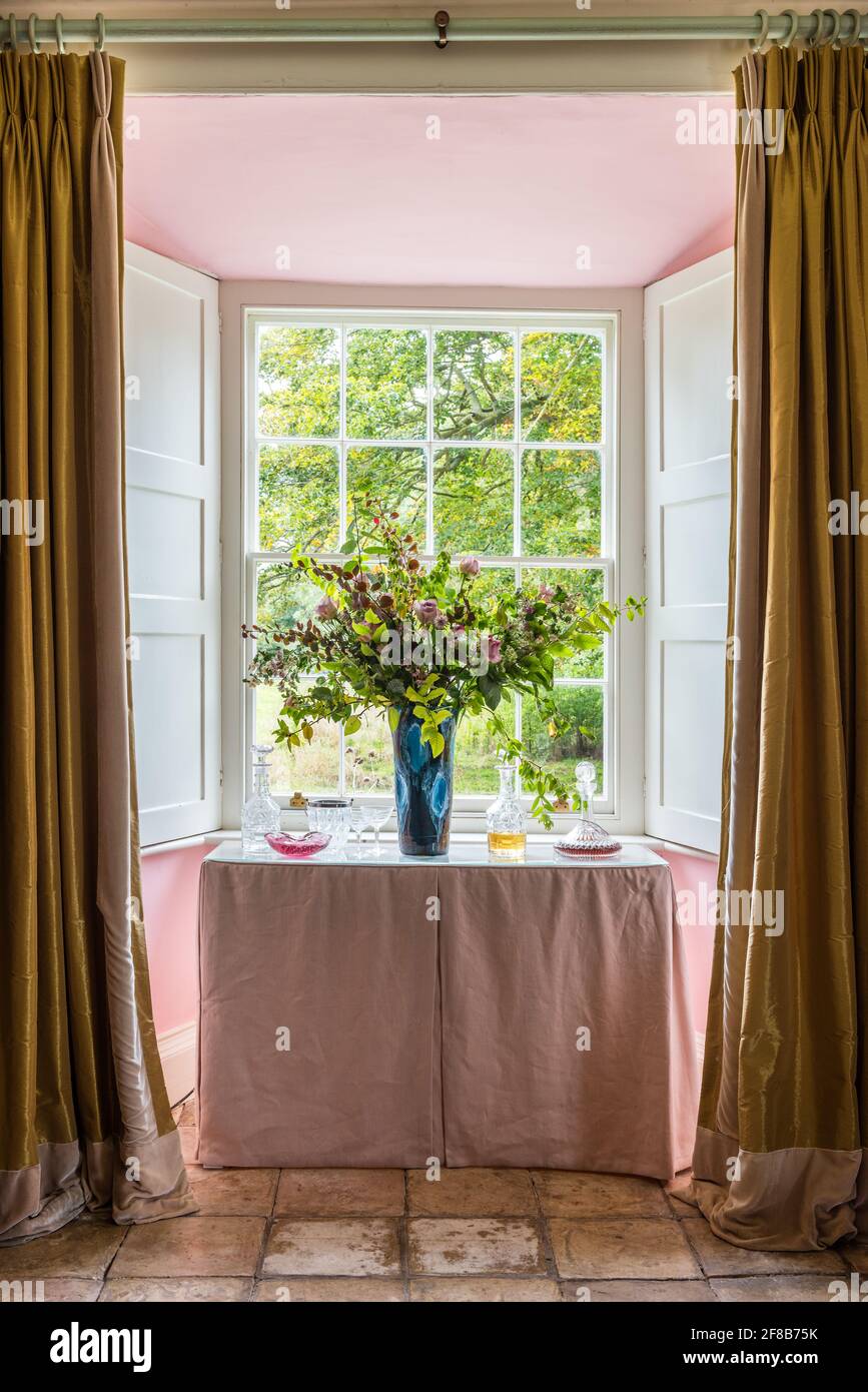 Gold silk curtains in bay window of Grade II listed Suffolk farmhouse with walls in Angie by Paint Library London Stock Photo
