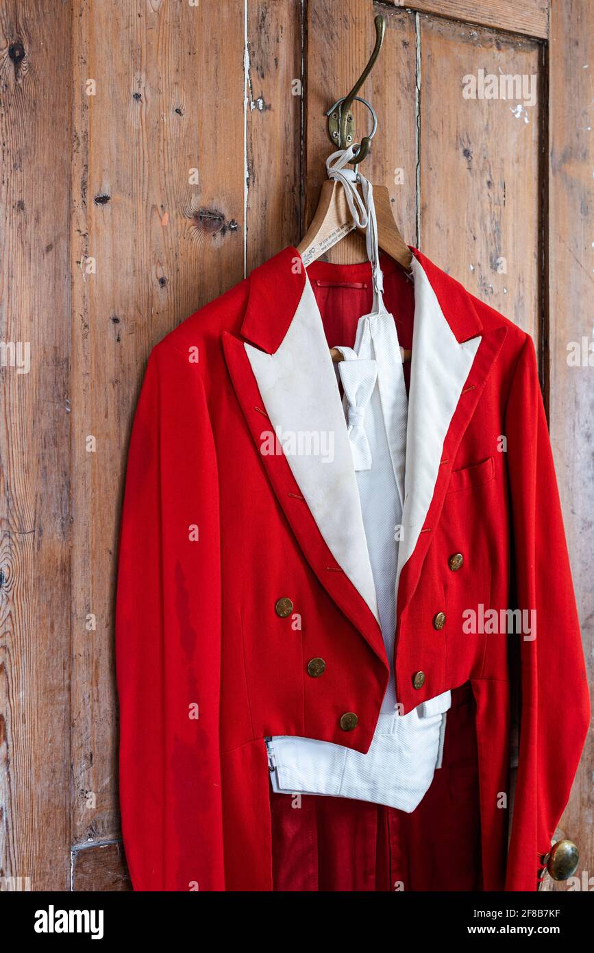 Antique red menswear hangs in Grade II listed Suffolk farmhouse Stock Photo