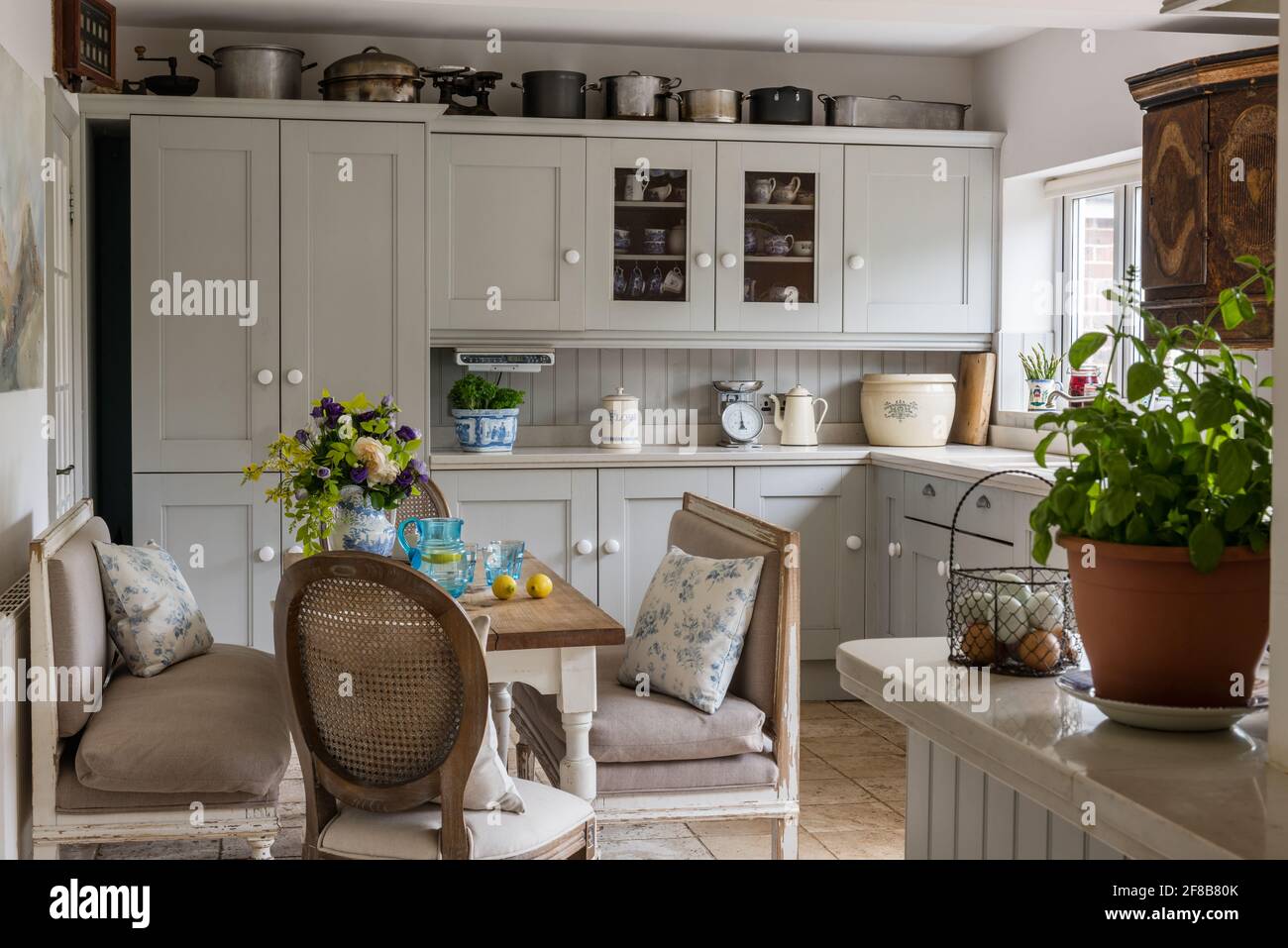 Shaker style kitchen with Gustavian benches in 1930s West Sussex coastal renovation. Stock Photo