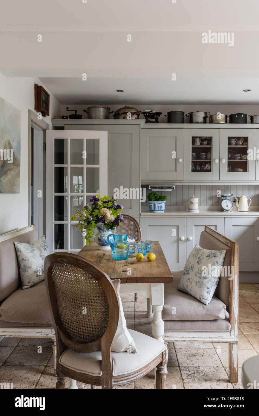Shaker style kitchen with Gustavian benches and Travertine floor in