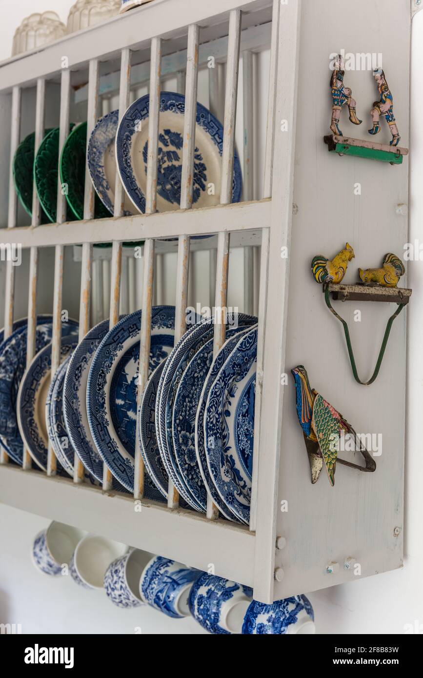 Vintage plates in rack with tongs in West Sussex kitchen. Stock Photo