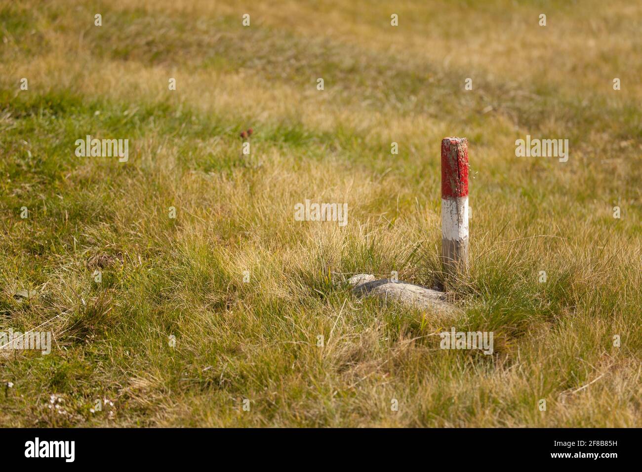 a typical red and white path sign among an Italian pasture in the ...