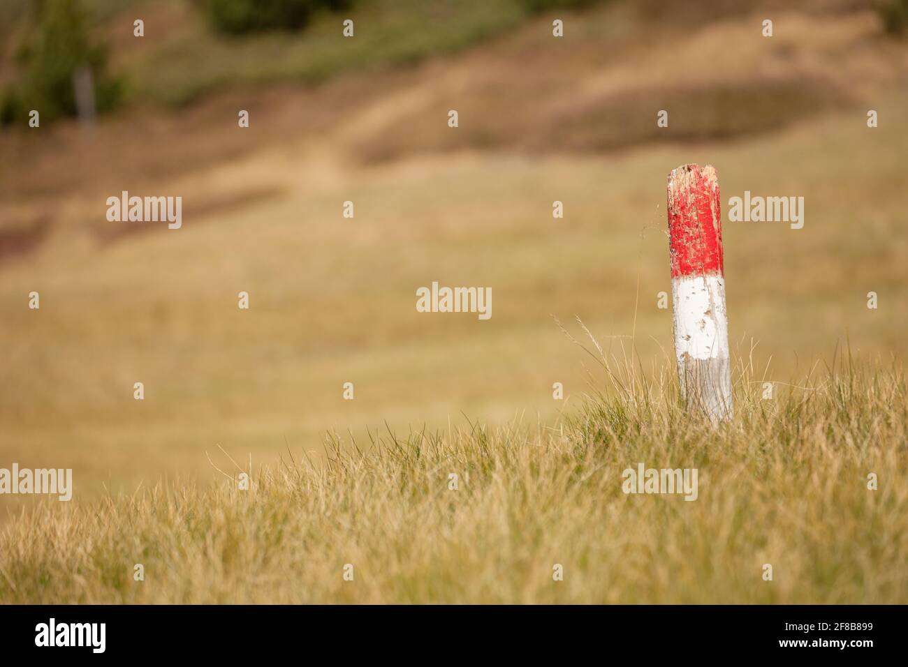 a typical red and white path sign among an Italian pasture in the ...