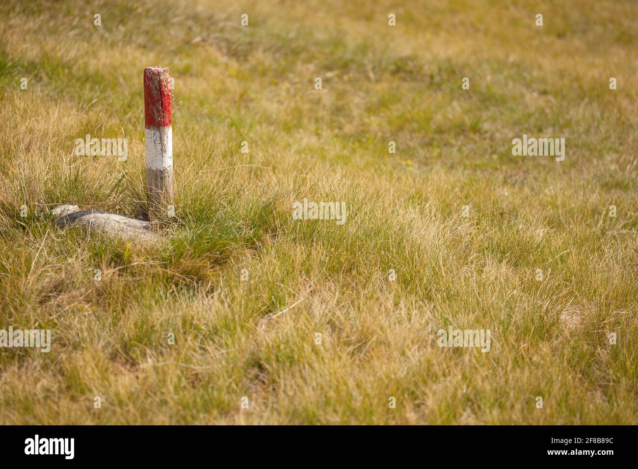 a typical red and white path sign among an Italian pasture in the ...