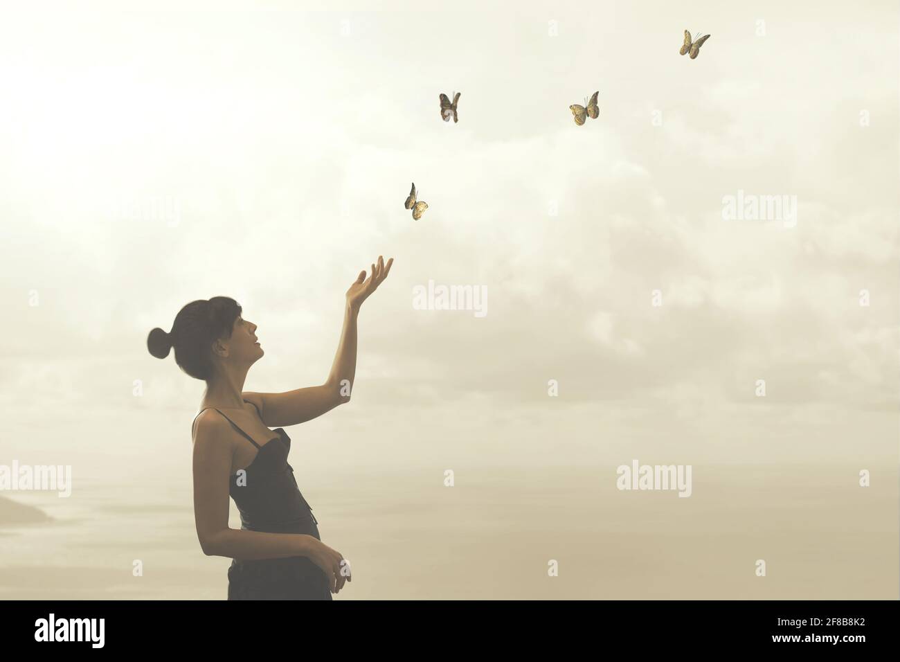 woman gently touches free flying butterflies Stock Photo