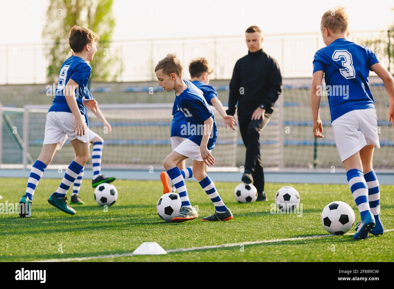 Group of school children playing training game with young coach. Kids