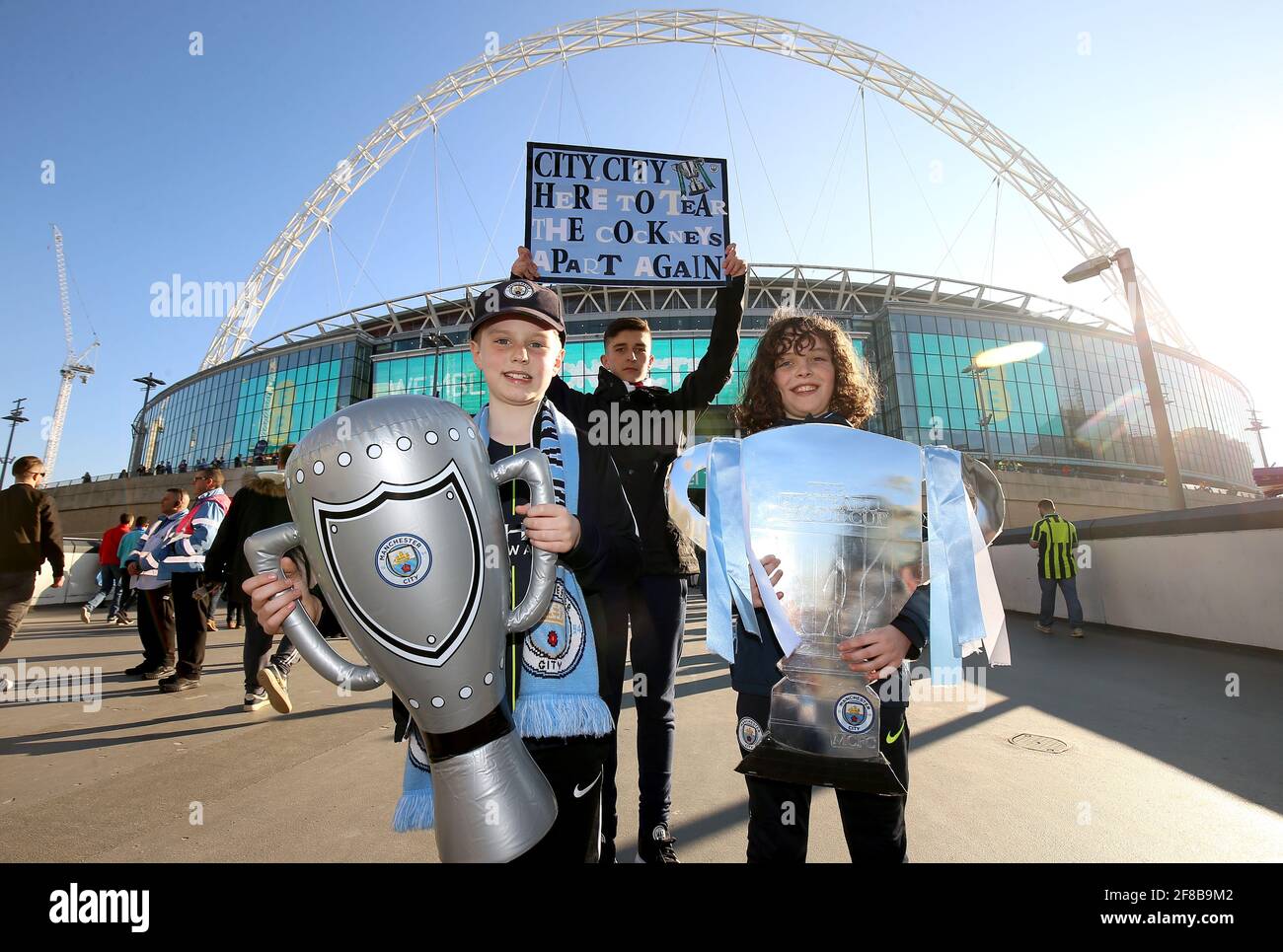 File photo dated 24-02-2019 of Manchester City fans hold up replicas of the Carabao Cup trophy prior to the beginning of the Carabao Cup Final at Wembley Stadium. Issue date: Tuesday April 13, 2021. Stock Photo