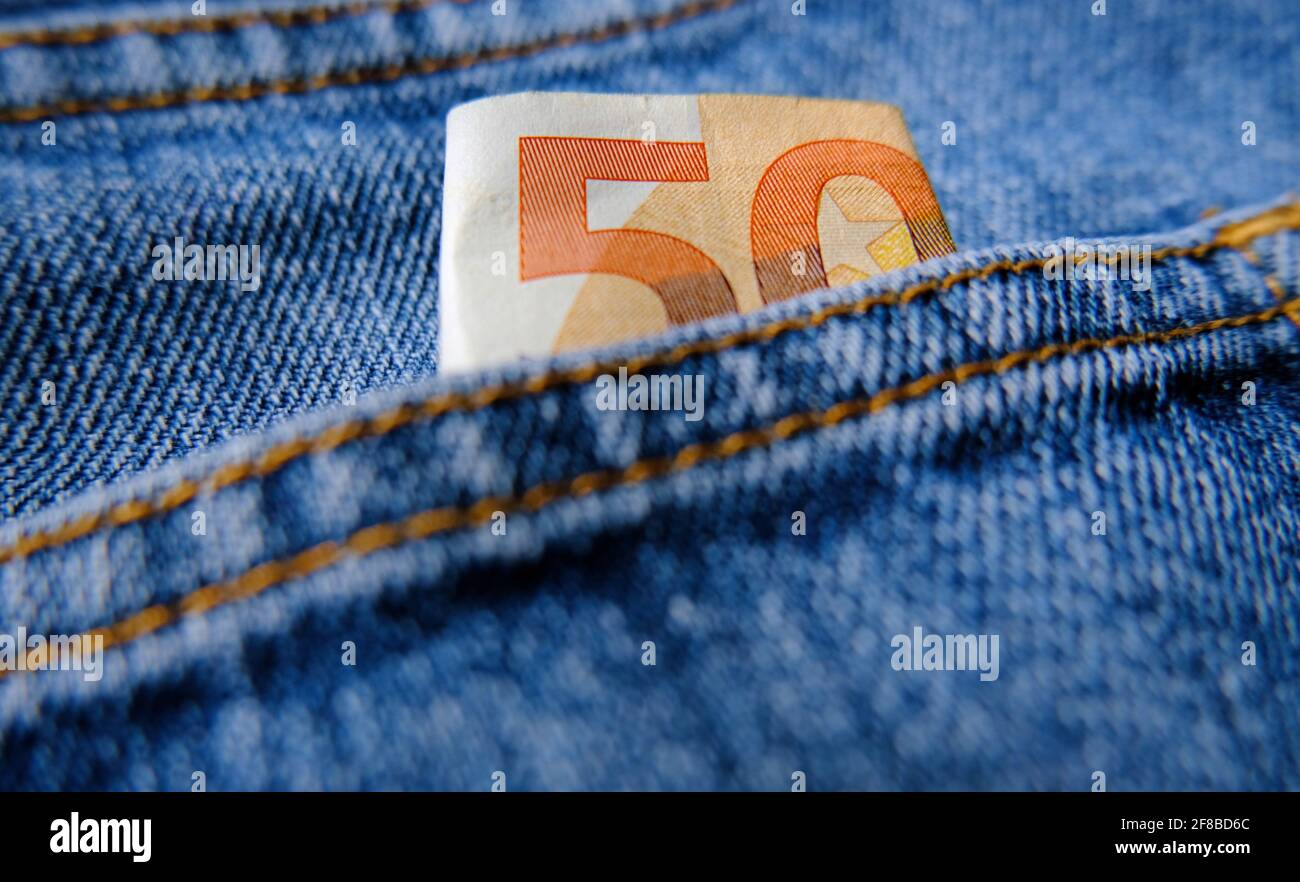 This image symbolizes 50 euro which are hidden in a jeans pocket - pocket money. Stock Photo
