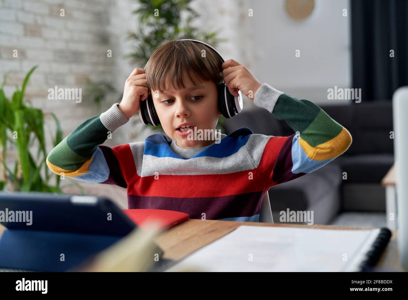 Boy in headphone during while studying at home Stock Photo