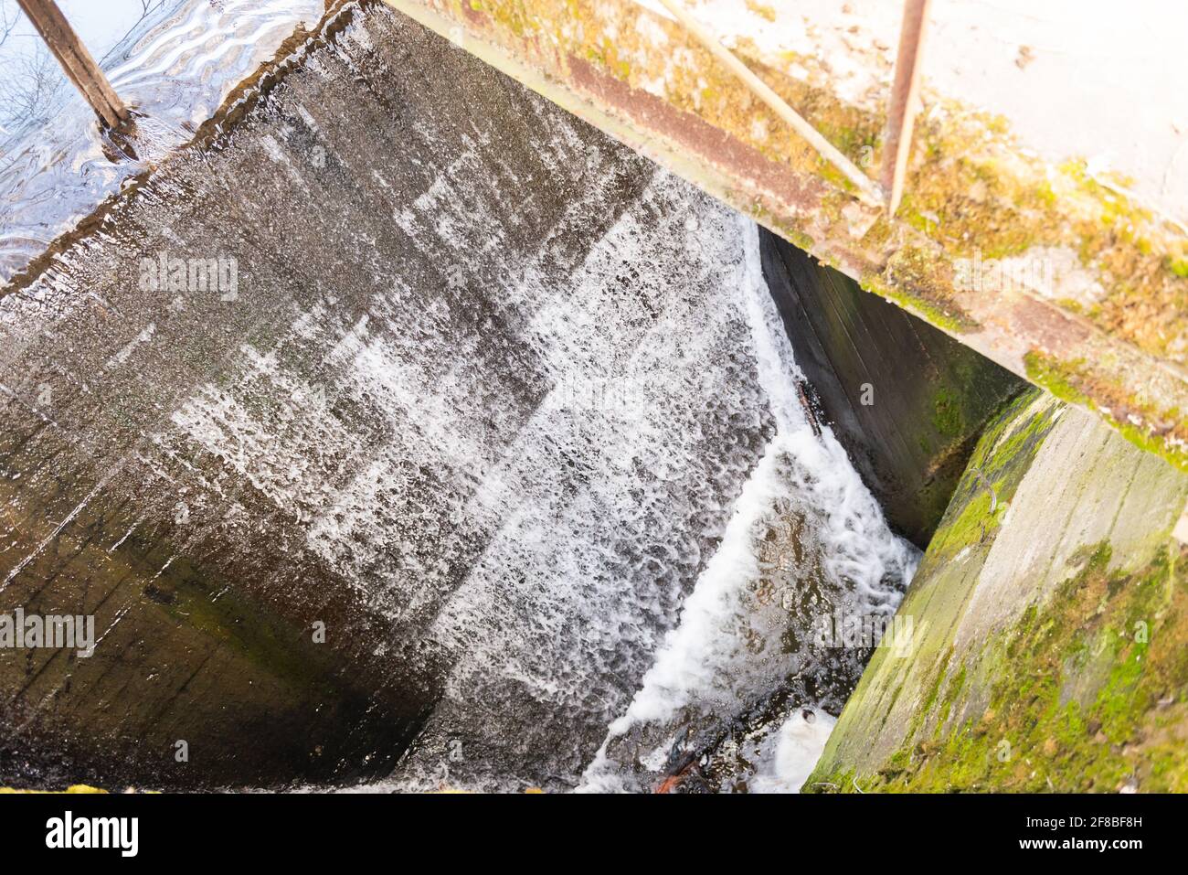 Draining water at a pond in Moscow. Water runoff to maintain pond level