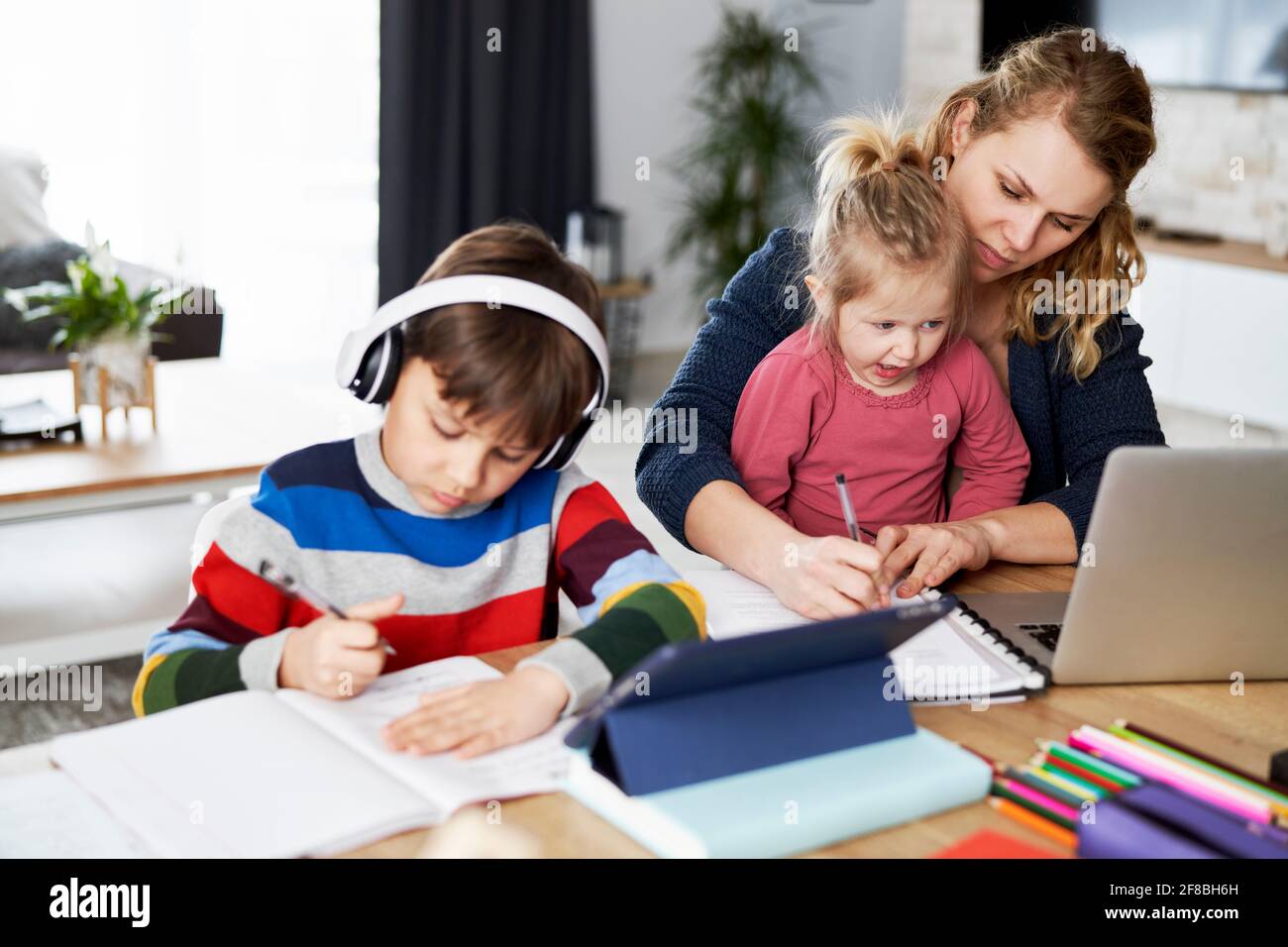 Mom tries to work while homeschooling Stock Photo