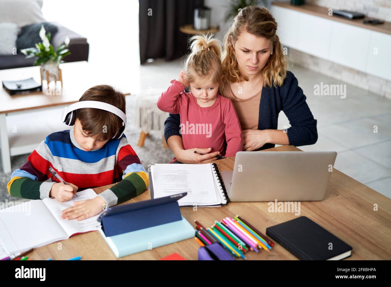 Mother working from home with young children in quarantine isolation Stock Photo