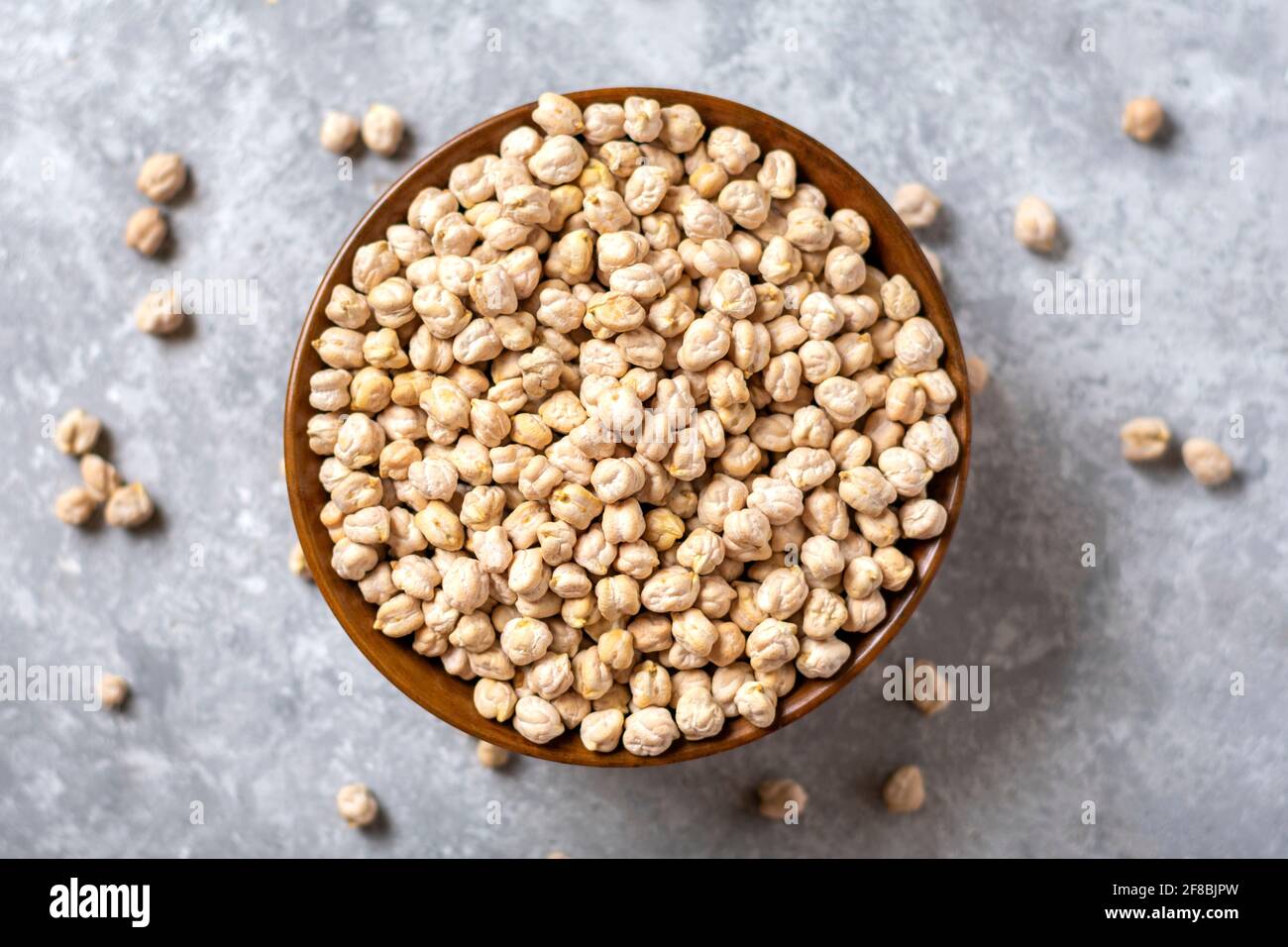 dry chickpeas in wooden bowl on concrete background Healthy eating, vegetable protein concept Top view Flat lay. Stock Photo