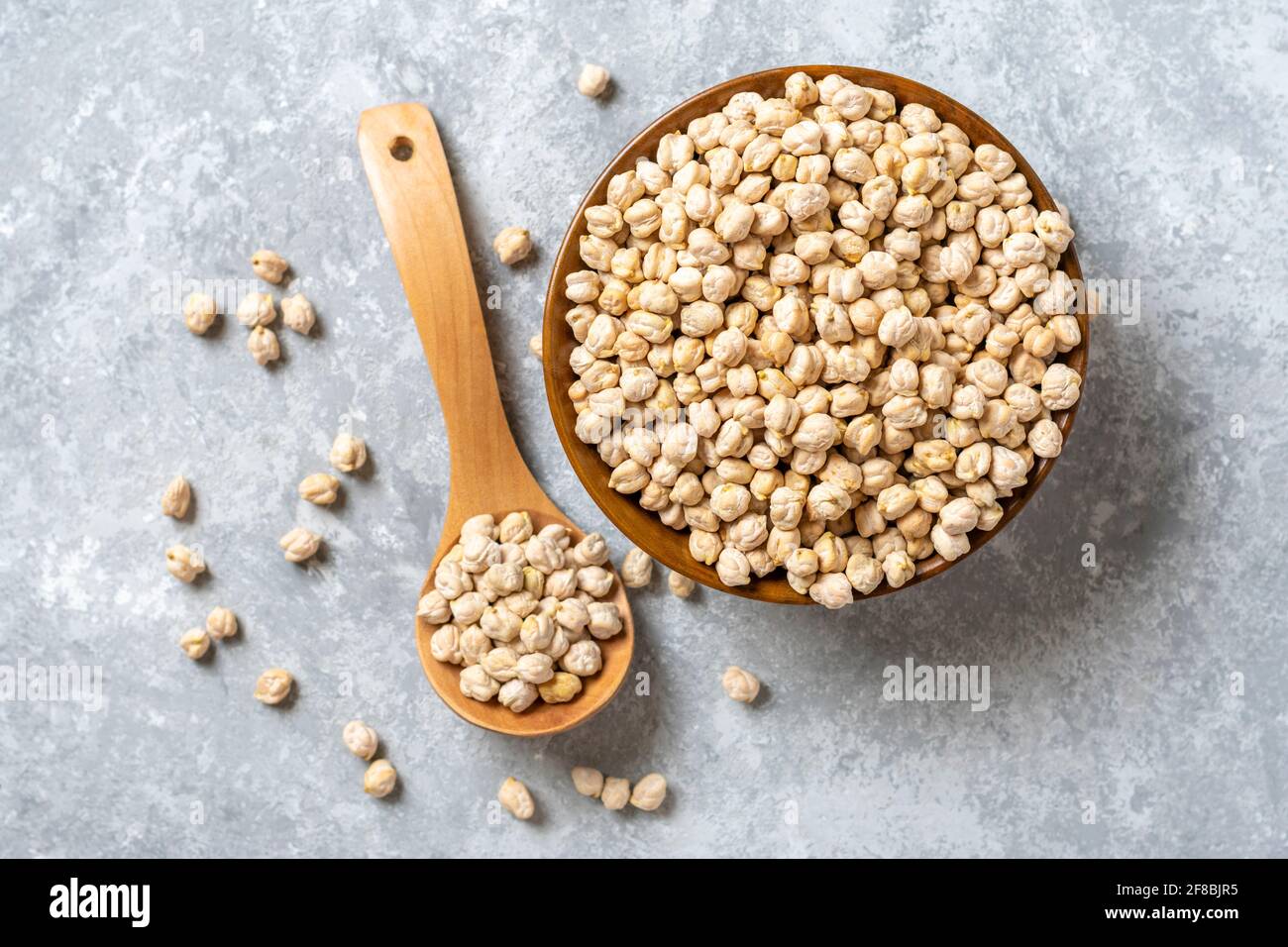 dry chickpeas in wooden bowl on concrete background Healthy eating, vegetable protein concept Top view Flat lay. Stock Photo