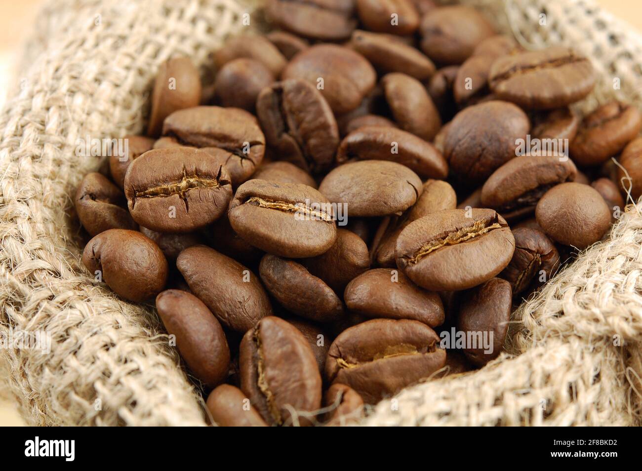 Roasted coffee beans in sacking bag. Selective focus. Stock Photo