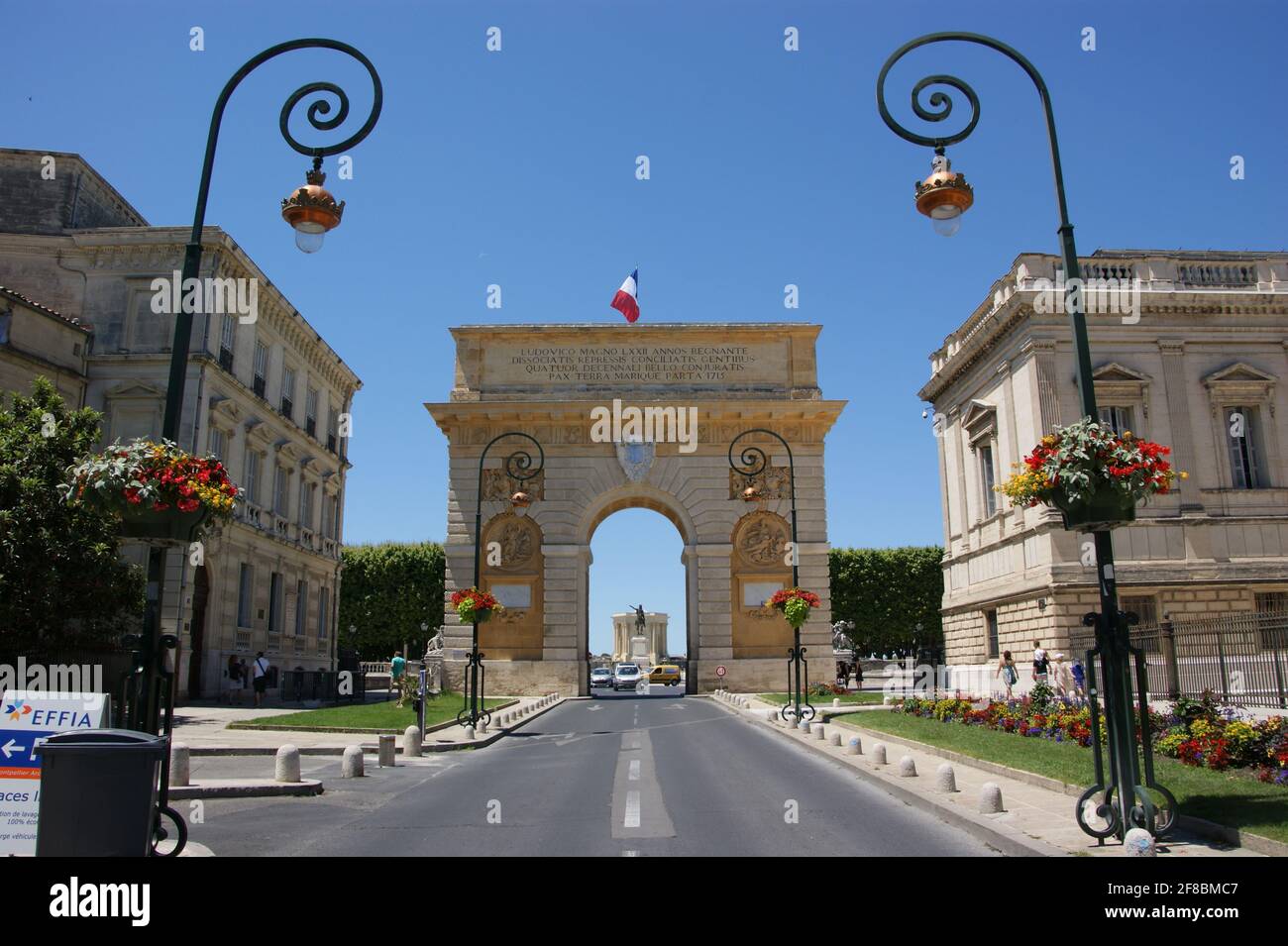 Equestrian statue of the Sun King, Louis XIV is seen through the Arc de Triomphe in Montpellier. Stock Photo