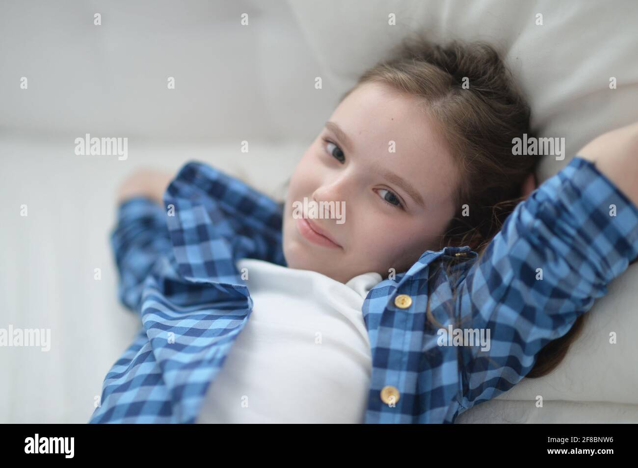 Cute little girl lying in bed at home Stock Photo Alamy